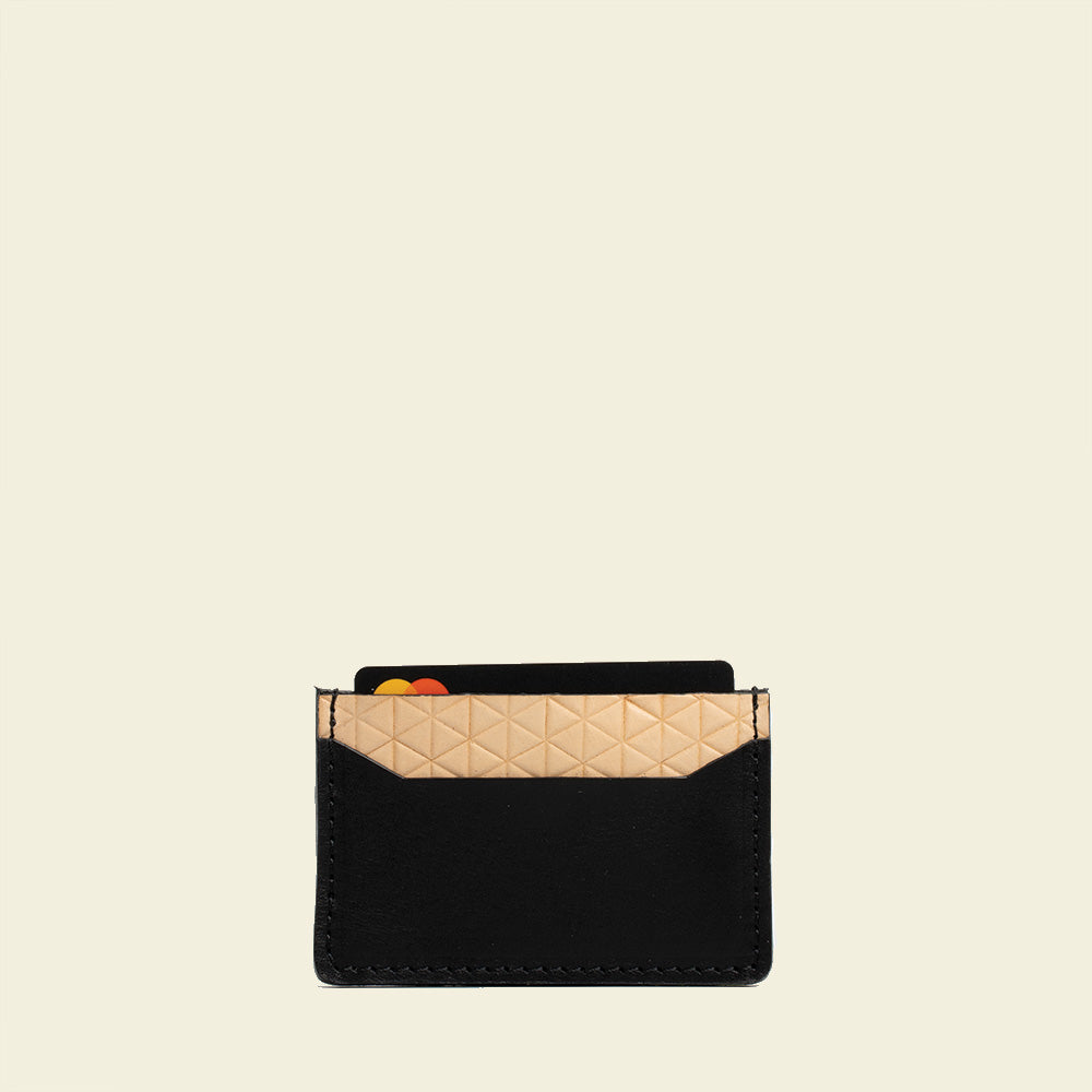 Minimalist leather card holder with geometric net design, handcrafted in Europe, holds two cards.