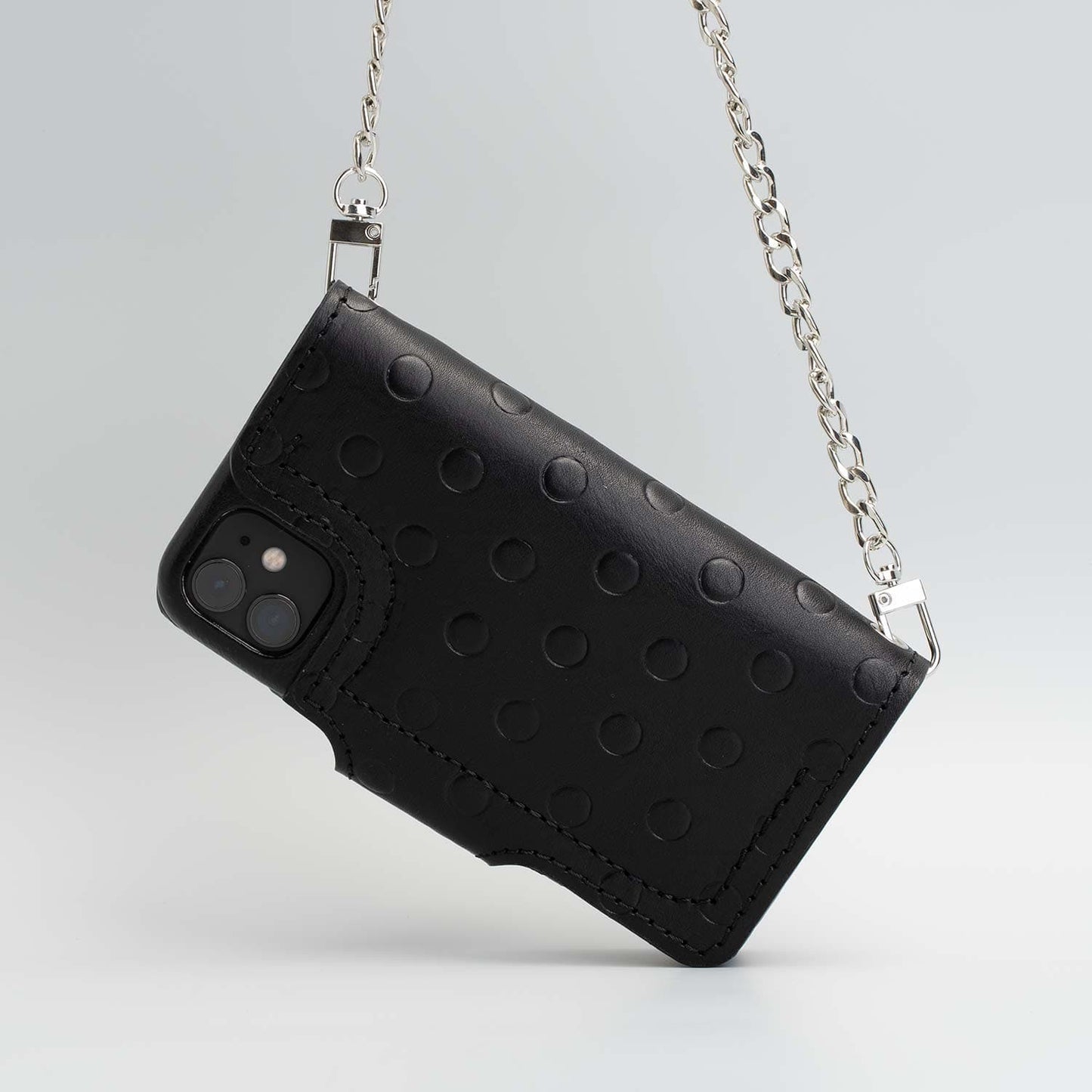 Black leather crossbody case with polka dot design and silver chain for iPhone 11.