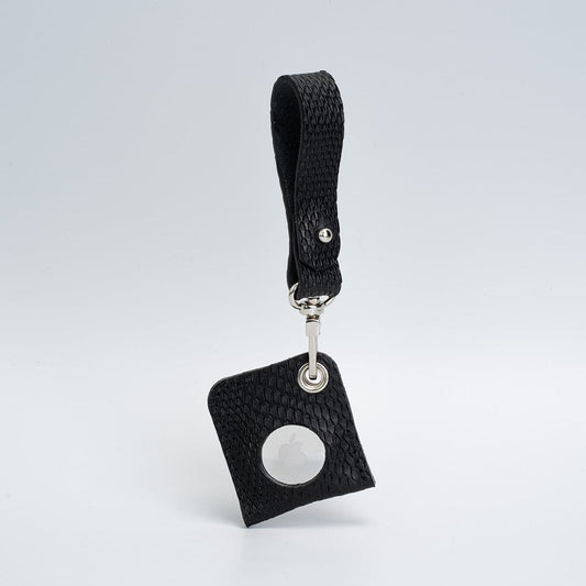 Black full-grain Italian leather AirTag bag charm with textured pattern and silver hardware