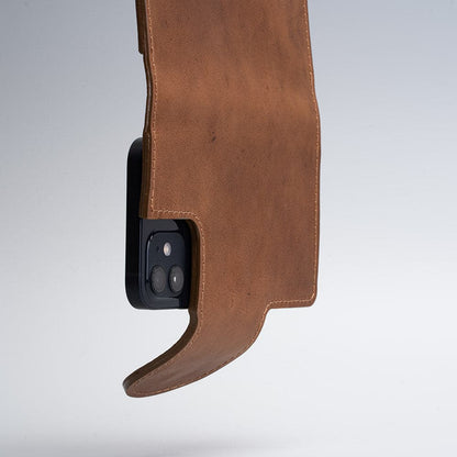 Brown leather folio wallet with MagSafe compatibility and magnetic closure hanging open on a smartphone