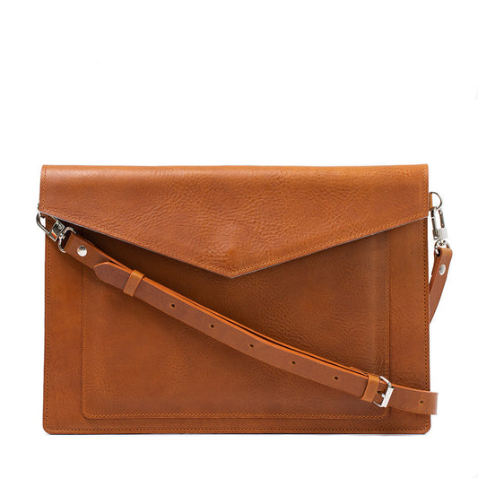Brown leather bag for MacBook with adjustable shoulder strap and front pocket for iPad.